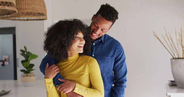Happy african american couple embracing and holding hands. Spending quality time at home together concept.