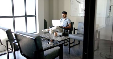 Businessman Using Laptop in Modern Meeting Room