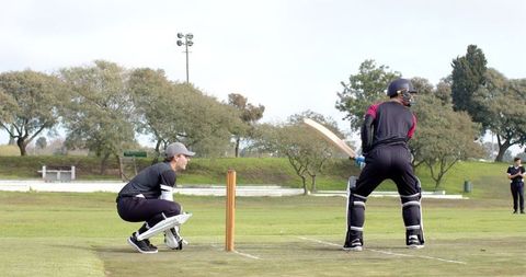 Competitive male cricket match on outdoor field