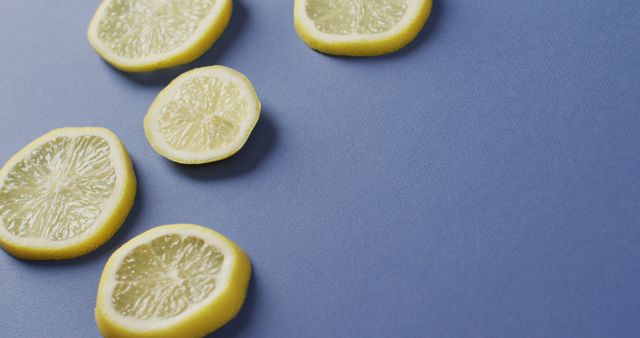 Image of slices of lemon lying on blue background with copy space. food, fruits, citrus, freshens and refreshment concept.