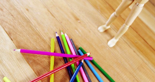 Colorful Pencils on Wooden Desk with Mannequin Standing - Download Free Stock Images Pikwizard.com