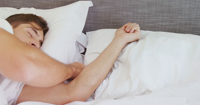 A young Caucasian man is sleeping peacefully in a comfortable bed, with copy space - Download Free Stock Photos Pikwizard.com