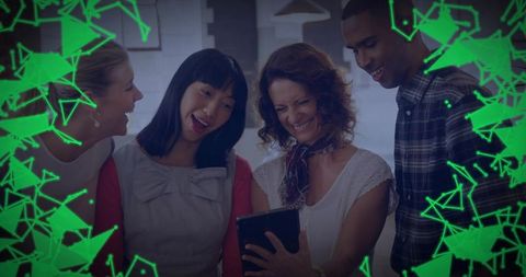 Smiling team gathering around tablet collaborating in modern office with green network overlay