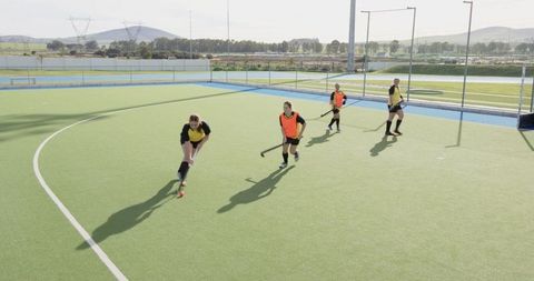 Female field hockey team training on outdoor turf