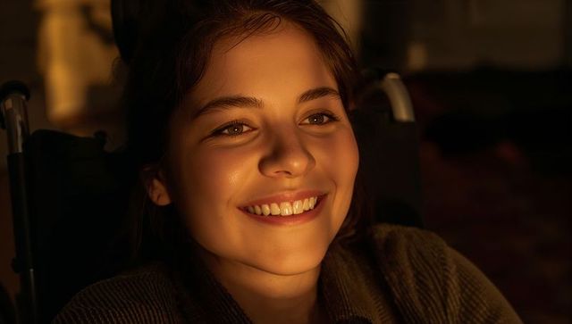 Smiling teen girl in wheelchair bathed in warm evening golden hour light