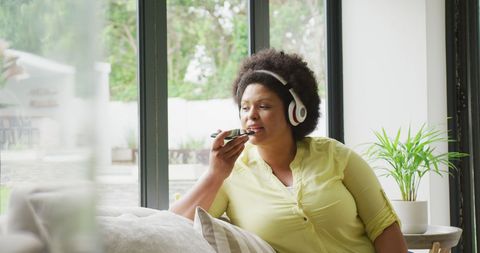 Relaxed Woman with Headphones Using Smartphone at Home