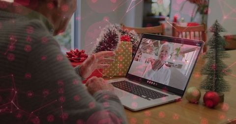 Senior man video calling with laptop during festive celebration