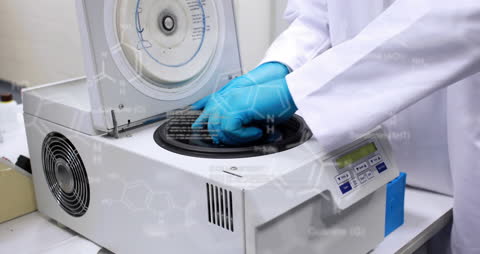 Scientist Operating Laboratory Centrifuge in High-Tech Setting