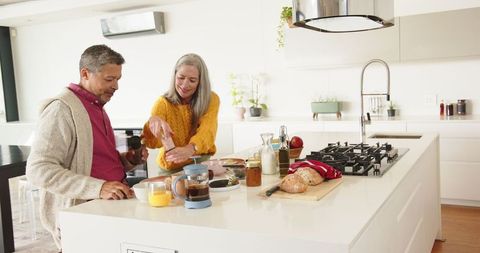 Diverse Senior Couple Cooking Together in Modern Kitchen
