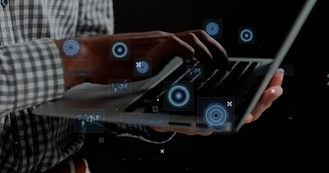 Man typing on laptop with futuristic holographic interface, hud and digital data overlays