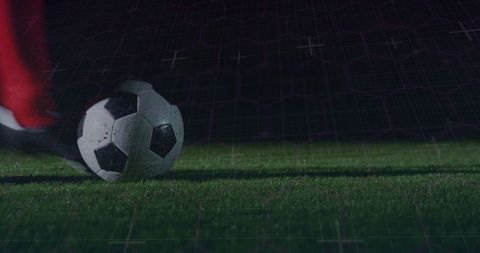 Soccer Ball Beneath Cleat with Digital Grid and Night Backdrop
