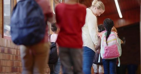 Teacher Engaging with Schoolchildren in Corridor