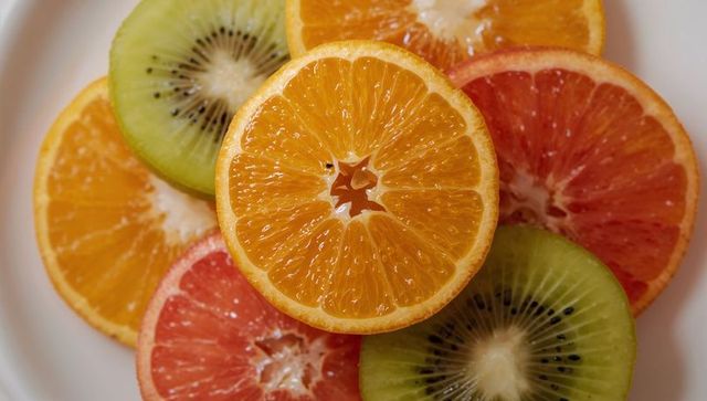 Assorted Citrus and Kiwi Slices on White Plate Displaying Vibrant Colors