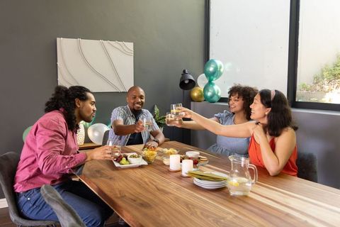 Diverse Friends Celebrating at Dining Table with Drinks