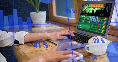 Typing hands on laptop with sports scoreboard and analytics overlays for remote work