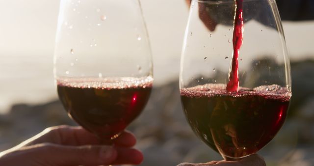 Close-Up of Two Wine Glasses Toasting at Sunset on Beach - Download Free Stock Images Pikwizard.com