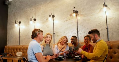 Diverse friends enjoying conversation in cozy cafe