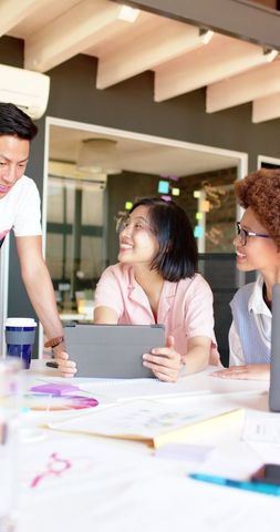 Diverse Team Collaborating with Tablet in Modern Office Environment