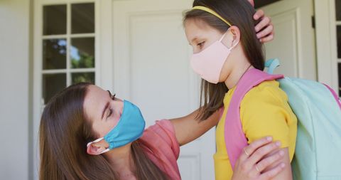 Mother and Daughter Wearing Masks at House Entrance