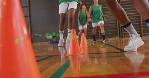 Athletes navigating agility cones on indoor basketball court
