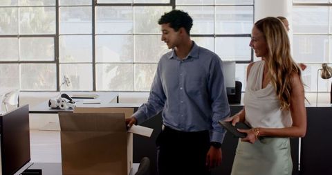 Professionals organizing office workspace with team spirit