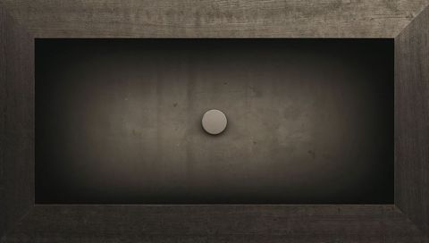 Minimalist monochrome wall panel with centered metal disc and rustic wood frame