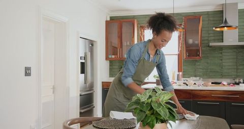 Woman Setting Table in Modern Kitchen for Family Celebration