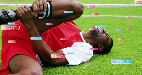 Athlete suffering knee injury on sports field clutching in pain