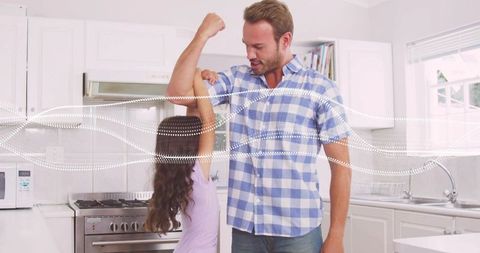 Father and daughter bonding in modern kitchen measuring muscle playful parenting moment