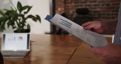 Professional Analyzing Business Charts in Modern Office