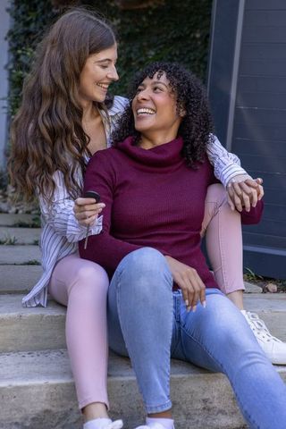 Diverse women embracing outdoors holding car key fob