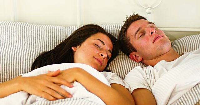 Couple sleeping in bedroom at home
