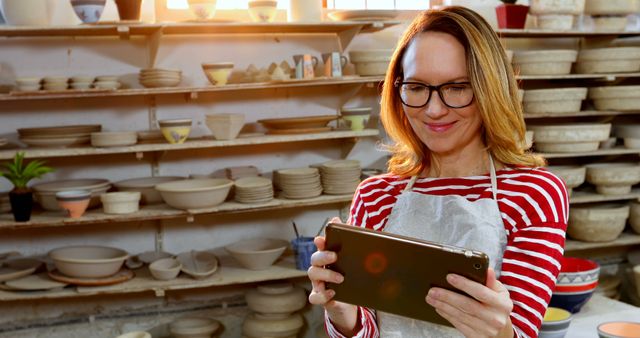 Smiling Female Potter with Tablet in Ceramic Workshop - Download Free Stock Images Pikwizard.com