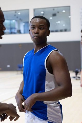 Determined Basketball Player at Indoor Gym Listening to Teammate