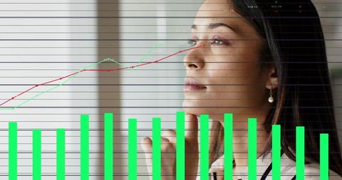 Businesswoman studying financial charts contemplating green bar graphs and line trends