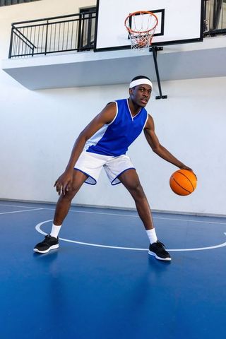 Athlete dribbling basketball indoor court