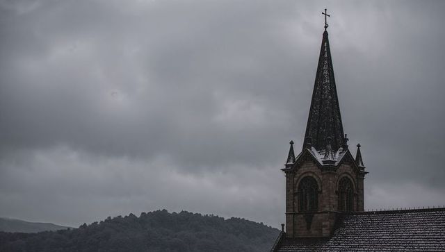 Gothic church spire rising over snow-dusted roof under moody cloudy winter sky