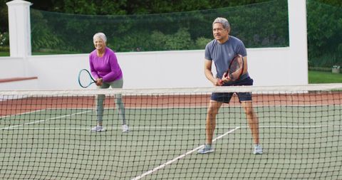 Senior Biracial Couple Playing Tennis Enjoying Active Lifestyle