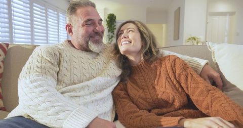 Cozy Couple Relaxing on Sofa in Knit Sweaters at Home