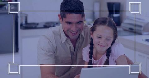 Father and daughter learning on laptop in bright kitchen sharing smiles and family bond