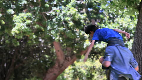 Father Carrying Son on Shoulders in Lush Park