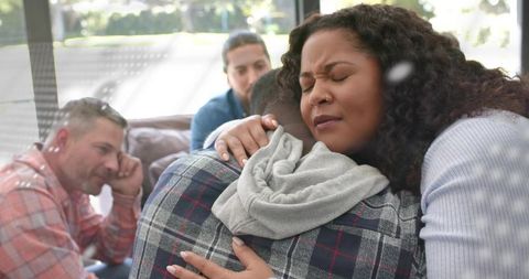 African american woman consoling young man on sofa showing empathy and support