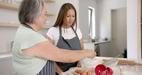 Grandmother and Granddaughter Bonding Over Baking in Kitchen