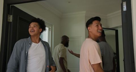 Joyful Friends Greeting Each Other with High-Fives and Smiles at Home