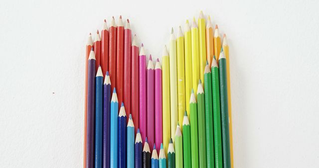 Colored pencils are arranged in a gradient pattern from dark to light shades, with copy space. This arrangement showcases a creative and organized approach to art supplies.