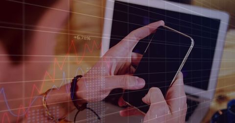 Hands Navigating Smartphone With Financial Data and Charts Overlay