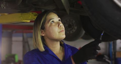 Female Car Mechanic Examining Vehicle Underframe in Workshop - Download Free Stock Images Pikwizard.com