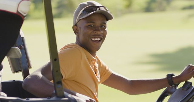 Image of happy african american man sitting in cart on golf filed. sporty, active lifestyle and playing golf concept.