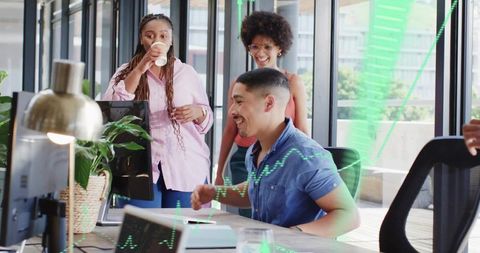 Celebrating rising charts while collaborating at sunlit modern open-plan office desk