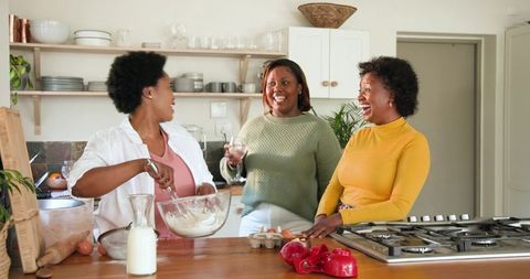 Three Friends Sharing Joyful Cooking Experience at Home